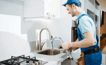Idraulico al lavoro per un intervento rapido di riparazione di un lavandino in una cucina moderna a Roma.