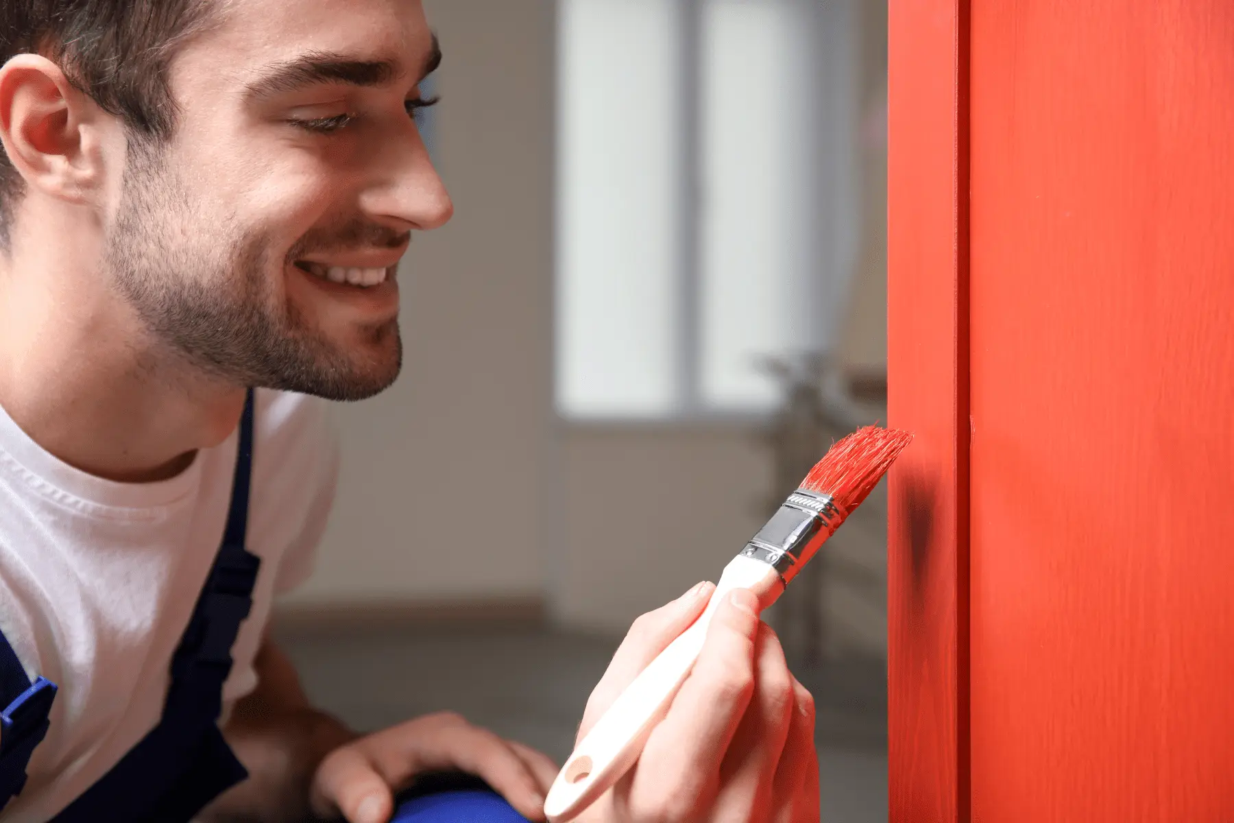 Un nostro imbianchino sorridente che lavora sui dettagli, a rappresentare un servizio trasparente con preventivi chiari e senza sorprese