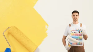 Imbianchino professionista a Roma con rullo e mazzetta colori, pronto per servizi di verniciatura, posa carta da parati e trattamenti antimuffa