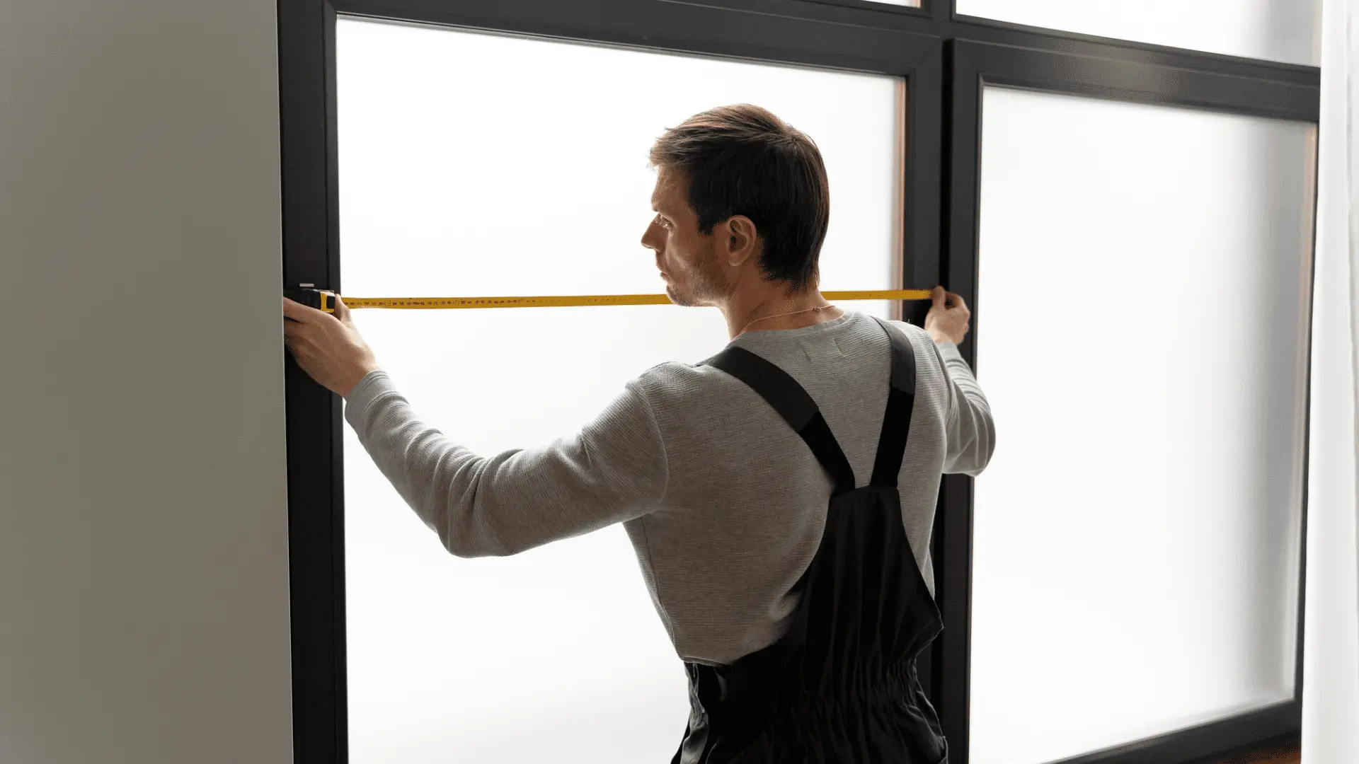 Tecnico che prende le misure per un'installazione rapida e flessibile di un infisso in PVC su misura a Roma.
