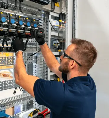 Tecnico specializzato durante l'installazione o la riparazione di componenti su un impianto elettrico per garantire la massima efficienza e sicurezza.