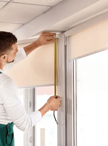 Tapparellista professionista che prende le misure precise di una finestra per l'installazione di una nuova tapparella su misura a Roma.