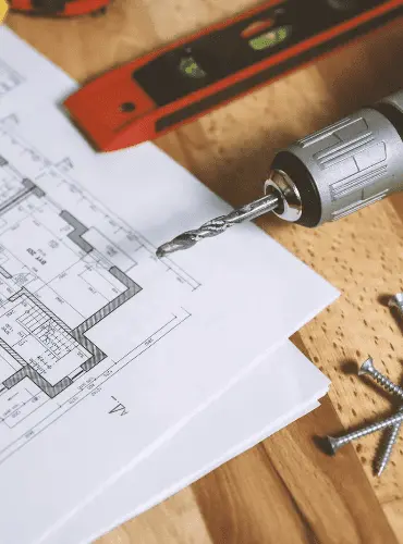 Primo piano di un progetto di ristrutturazione con strumenti da muratore come trapano e livella, che simboleggia la precisione dei nostri lavori edili a Roma.