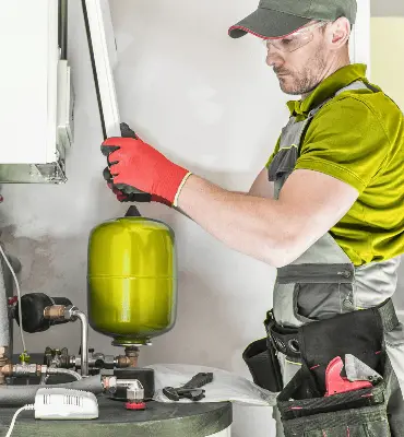 Tecnico esperto di Edil Alba Restauri che esegue la manutenzione di uno scaldabagno e la riparazione di una caldaia, servizio di assistenza H24 a Roma