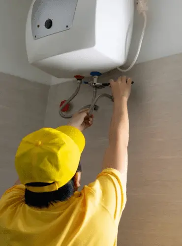 Tecnico esperto di Edil Alba Restauri che esegue la manutenzione di uno scaldabagno e la riparazione di una caldaia, servizio di assistenza H24 a Roma