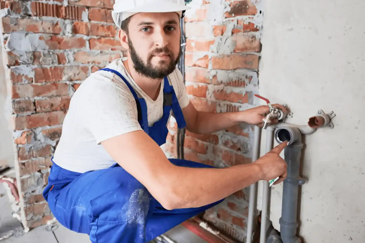 Idraulico professionista durante l'installazione di un impianto idraulico in fase di ristrutturazione