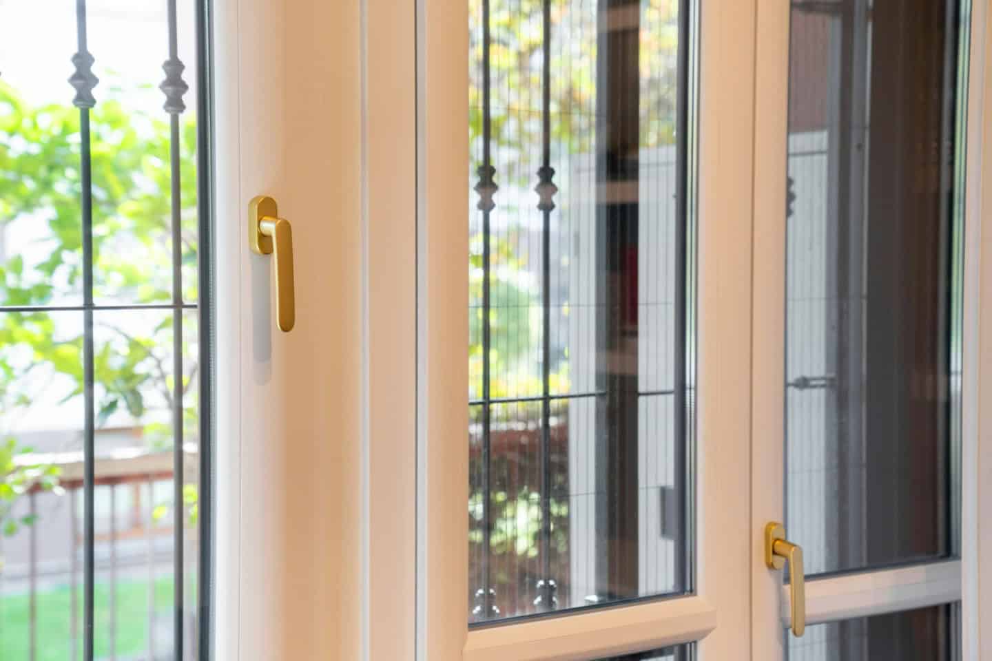 Porta finestra in PVC con vetri doppi e maniglia dorata.